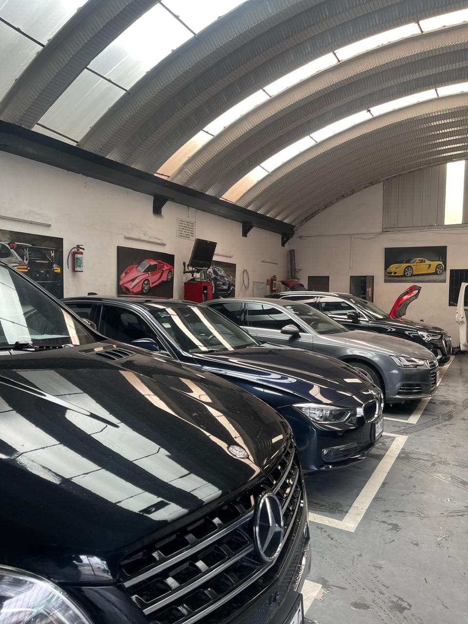 Interior del taller con varios autos europeos en servicio